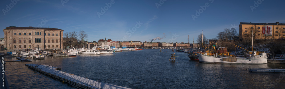 Panorama at the bridge Skeppsholmsbron, museum buildings and moored harbor ferries a sunny winter day in Stockholm