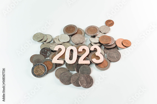 Wooden text of 2023 on pile of money  money saving concept  financial and business growth  white background