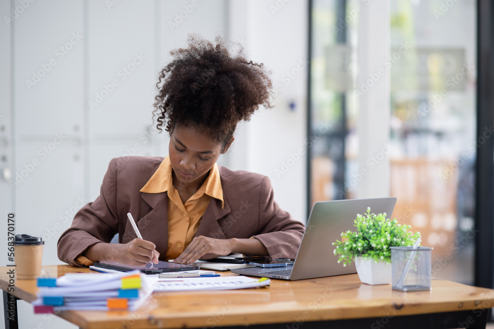 Young African American businesswoman working with pile of documents at office workplace, business finance and accounting concepts. Young African American businesswoman working with pile of documents at office workplace, business finance and accounting concepts.