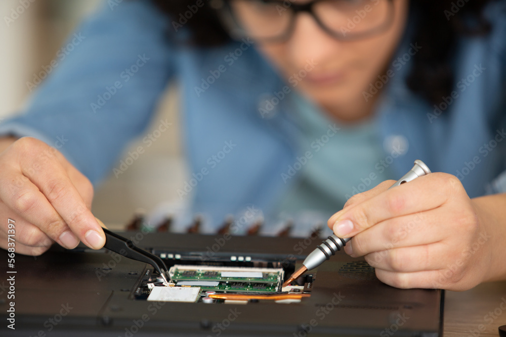 female unscrewing part of a laptop female unscrewing part of a laptop