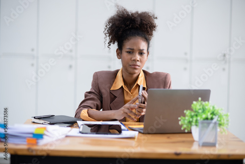 Young African American businesswoman working with pile of documents at office workplace,  feeling sick at work, stress from work, overworked, problem, unhappy.	