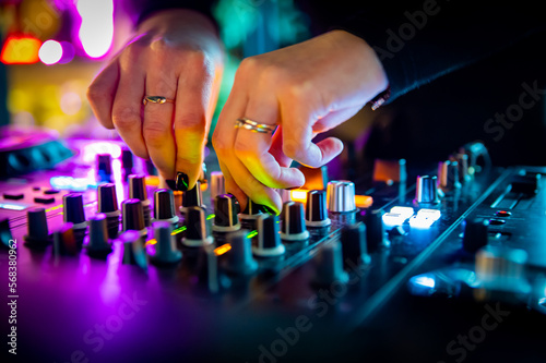 DJ Hands creating and regulating music on dj console mixer in concert nightclub stage