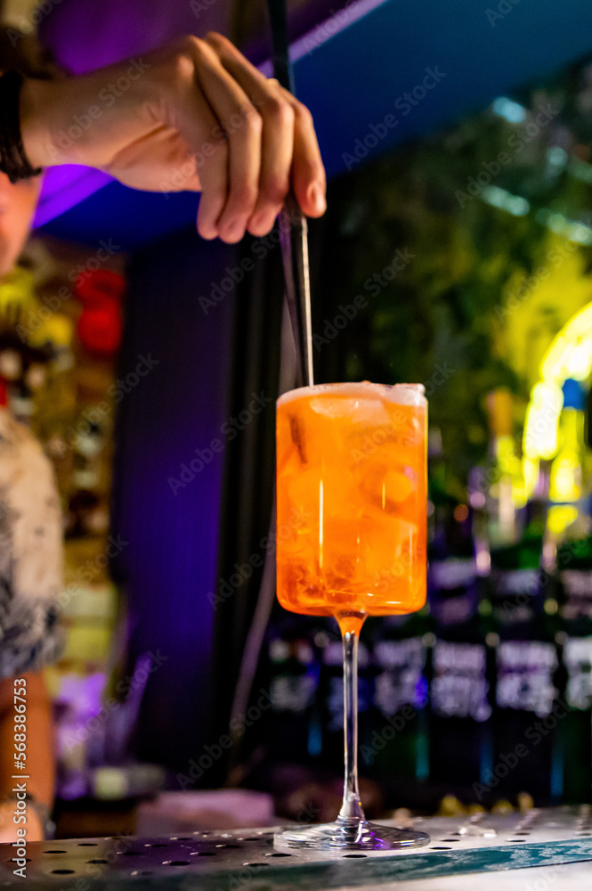 man hand bartender making sweet and sour refreshing Aperol Spritz cocktail on the bar counter man hand bartender making sweet and sour refreshing Aperol Spritz cocktail on the bar counter
