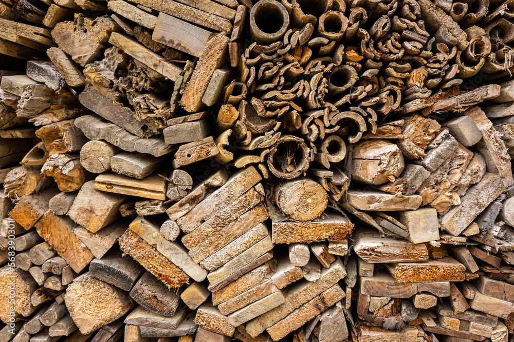 Background from stacked wooden boards of different shapes. Full surface texture of end pieces of wood pieces in shades of brown. Background from stacked wooden boards of different shapes. Full surface texture of end pieces of wood pieces in shades of brown.