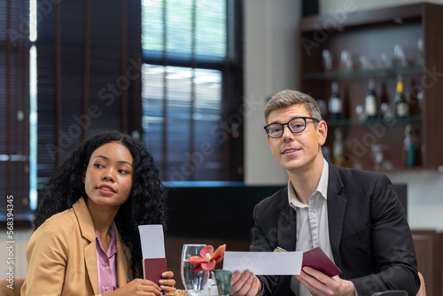 Two business workers are waiting and taking facility service at an exclusive airline lounge. Travelers get refreshment at a private lobby to be ready for their trip.