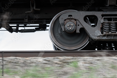 Wheels and bogie of freight train moving fast along railroad. photo