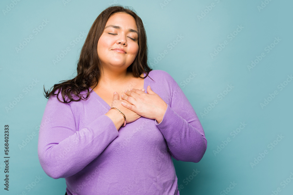 Thankful young woman touching her heart Thankful young woman touching her heart