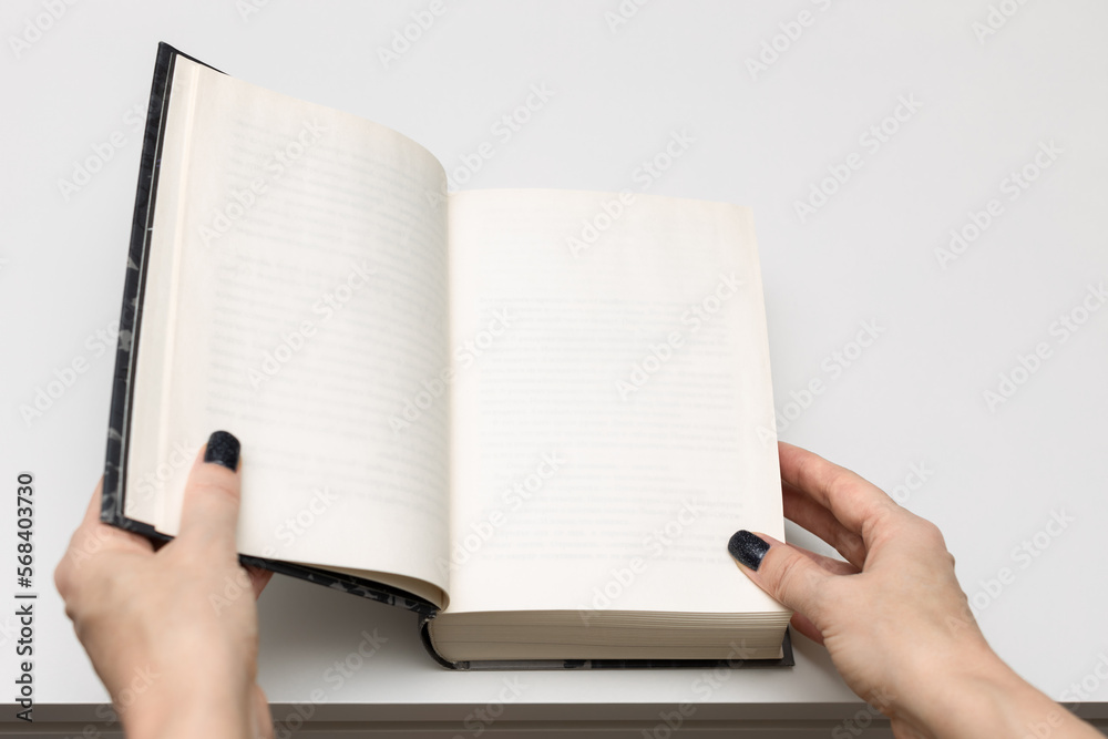 man opens a thick book lying on the table. man opens a thick book lying on the table.