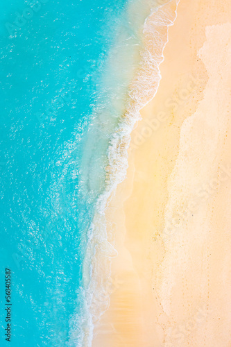 Summer seascape beautiful waves, blue sea water in sunny day. Top view from drone. Sea aerial view, amazing tropical nature background. Beautiful bright sea waves splashing and beach sand sunset light © icemanphotos