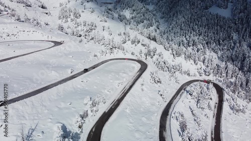Winding road in a aerial winter landscape. Alpine landscape. Vacations, travel, nature and tourism concept. 4k drone shot.