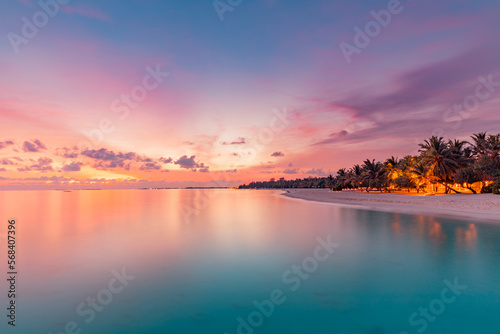 Beautiful panoramic sunset tropical paradise beach. Tranquil summer vacation or holiday landscape. Exotic sunrise beach seaside palm trees silhouette sea bay view inspirational seascape and sky clouds