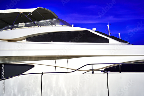 Abstract partial view of a luxurious white yacht with black windows against a blue sky