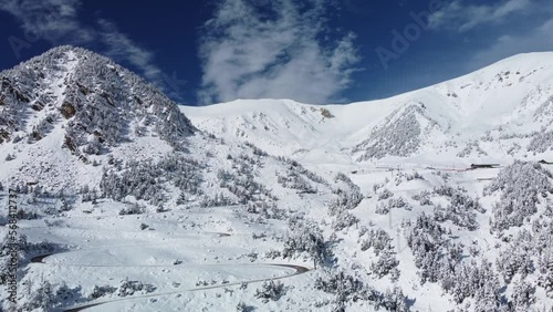 Vallter 2000 ski resort. Aerial winter landscape with winding road, snowy mountains. Ski station, cacations, travel and tourism concept. Setcases, Ripollés, Girona Pyrenees, Catalonia. 4k drone video. photo