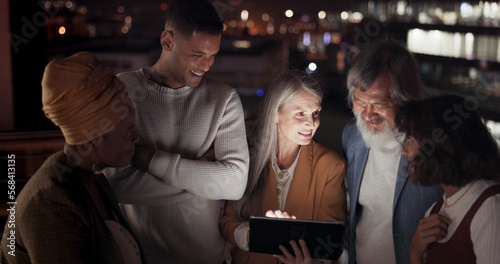 Tablet, collaboration and night with a business team working together in the city on their office balcony. Finance, teamwork and meeting with a man and woman employee group talking strategy outside