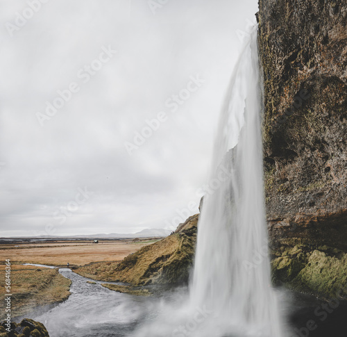 Iceland panorama with waterfall and a green field on an autumn day