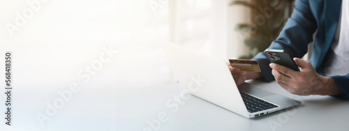 Person holding a credit card, uses a credit card to pay for goods and services online, the concept of using a credit card for online shopping, ordering goods and services on the website.