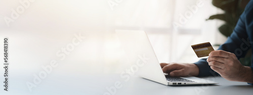 Person holding a credit card, uses a credit card to pay for goods and services online, the concept of using a credit card for online shopping, ordering goods and services on the website.