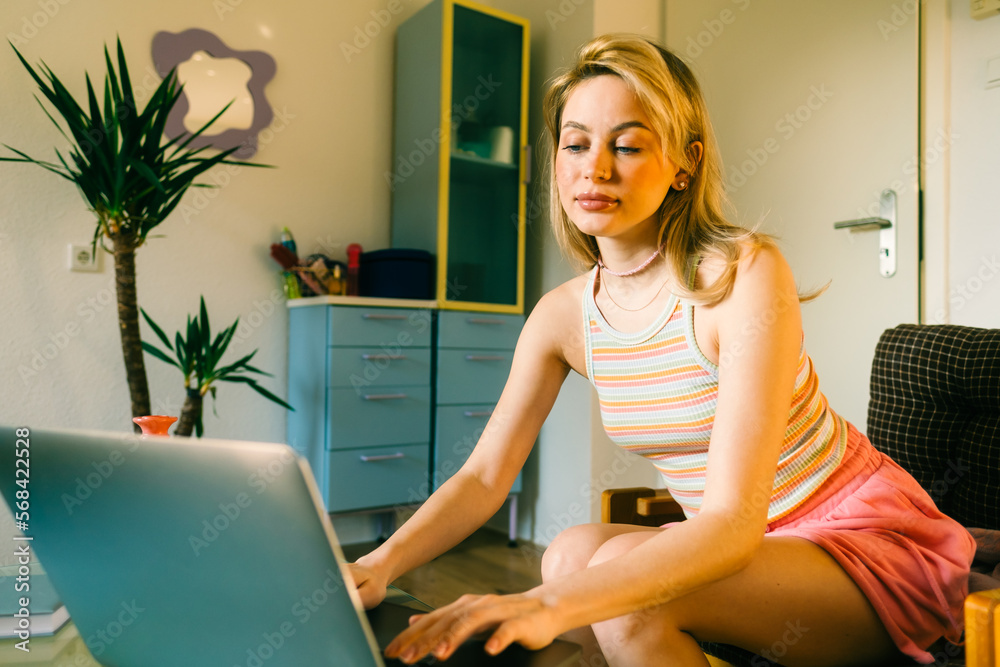 Portrait of young caucasian woman college student studying with laptop, distantly preparing for test exam, writing essay doing homework at home. Portrait of young caucasian woman college student studying with laptop, distantly preparing for test exam, writing essay doing homework at home.