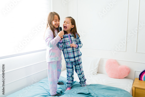 Canvas Print Beautiful little girls singing a song in pajamas