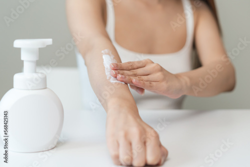 Body skin care routine concept. Close-up view hands of a young woman applying lotion cream on the hand