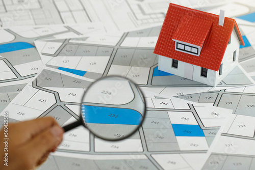 Принти на полотні Man holding magnifier on cadastre map search for assesses to buy the land lands
