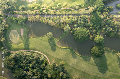 Landscape in golf course and water in lake or lakeside in aerial view. Include green field, lawn, grass. Design for golfers to play game, sport, outdoor recreation activity. © DifferR