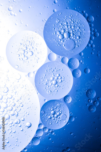 Blue oil bubbles background for cosmetic liquid beauty product. Face serum texture