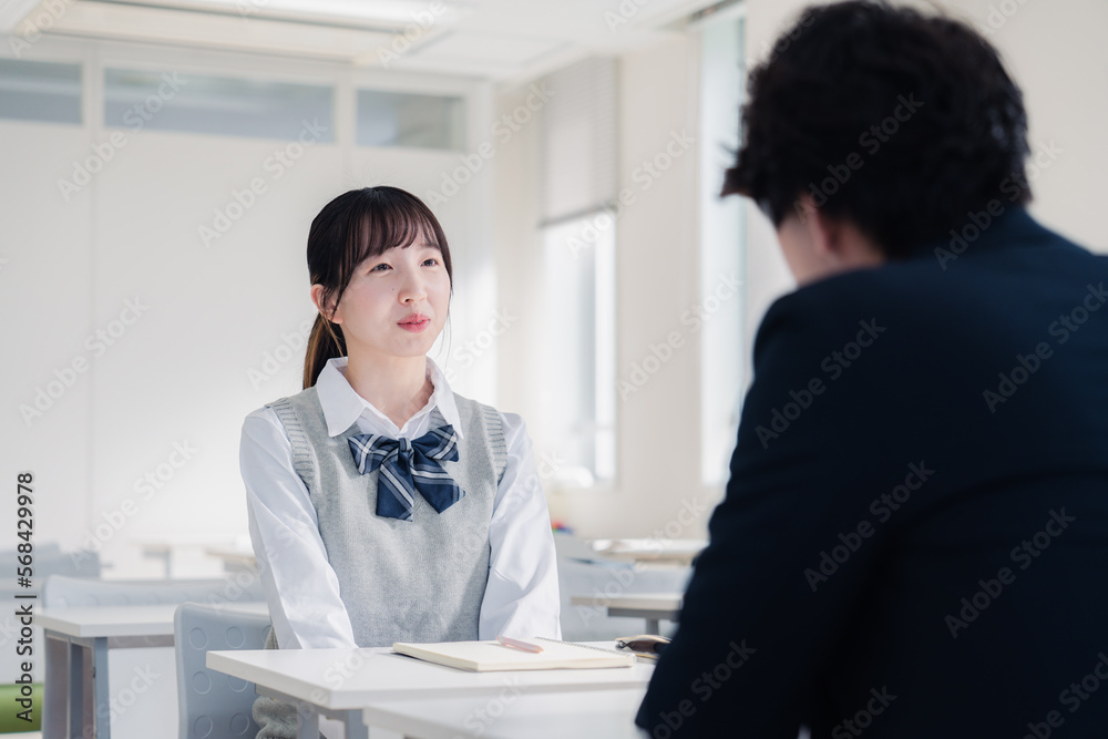 面談で進路指導を受ける女子高生