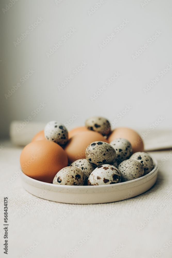 Easter eggs in the plate on beige background. Chicken and quail eggs Easter eggs in the plate on beige background. Chicken and quail eggs