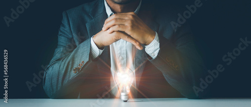 Принти на полотні Light blub under hands, businessman protects the light bulb, Creative new idea,