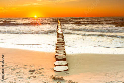 Sunset on the Baltic Sea in Rowy, Poland. Landscape with waterbreak in the sea under the sky at sunset. photo