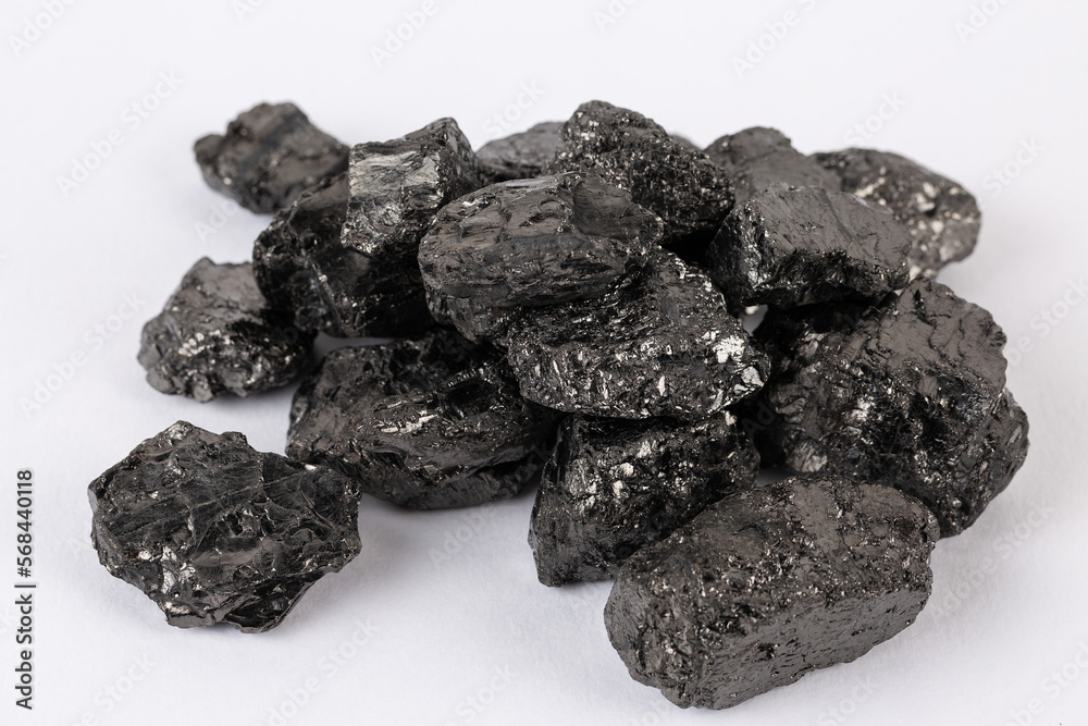 Fototapeta premium Heap of natural black fossil coal on a white isolated background.
