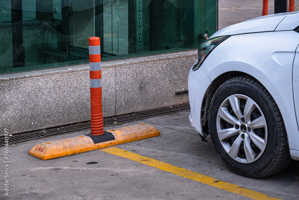 car park. red plastic bollard and yellow border line on concrete floor