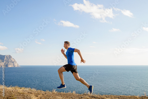 male runner running trail on sea coast