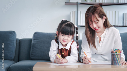 Asian family mother and daughter girl learning to read learning the alphabet , Mother helping her daughter with homework