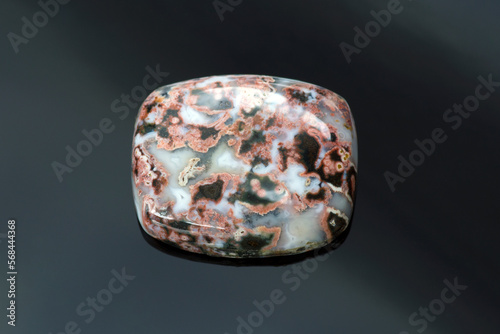 Natural ocean jasper cabochon loose polished gemstone. Barrel shaped, opaque gem with black and red veins pattern in white mossy base. Mined in Madagascar. Gemology, mineralogy, lapidary.