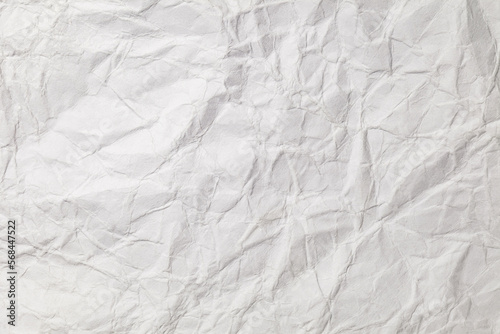 Crumpled white paper with bends and fractures  uneven surface  background texture  close-up