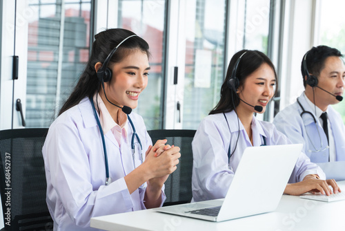 Portrait of Asian female doctor with headsets and stethoscope, using laptop computer advice medicines or medical treatment to patient. Online telemedical service from hospital clinic