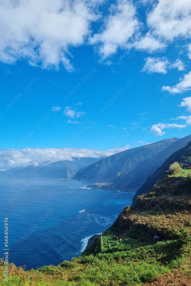 Green slopes of the mountains of Madeira island. The waves of the Atlantic Ocean wash the coast of the island.