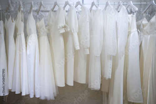 Different wedding dresses on hangers in boutique