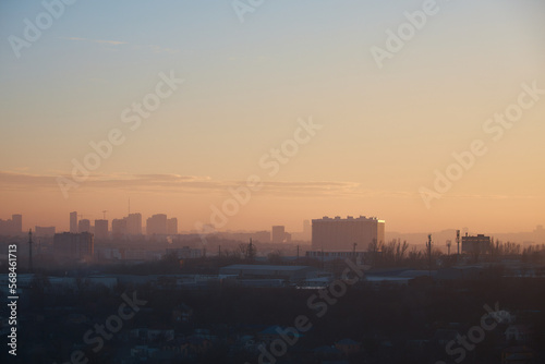 city at sunset  panorama of city  outlines of buildings  smog over industrial zone