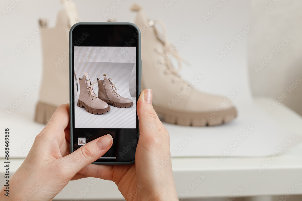 Woman takes a Picture of New or use Shoes on a Mobile Phone at Home. Mobile shooting goods for sale