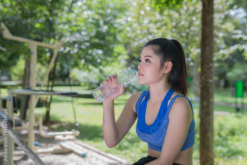 beautifull sport girl drinking water at the public park court and wearing blue sport bra