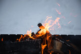 Flames. Wood in the fire. Fire in the grill. The orange color of the flame on the background of white snow.