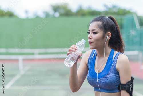 beautifull sport girl drinking water at the tennis court and wearing blue sport bra