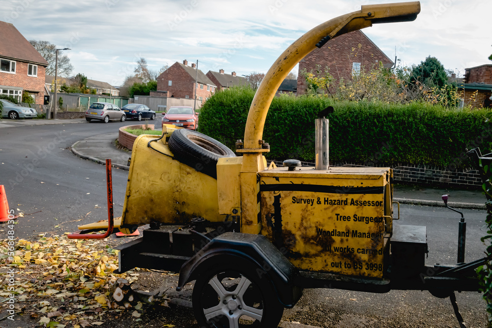 A commercial towable engine powered drum woodchipper with hopper