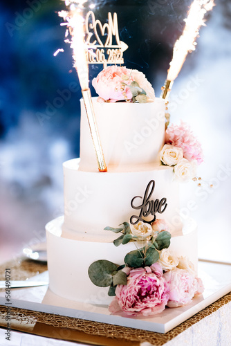 Wedding cake cutting cut with knife bride and groom love torte together couple in restaurant luxury party blue lights sweet table delicious torte gâteau rose flowers white chocolate married party 