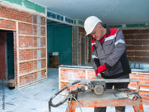 Man builder uses tile cutte...