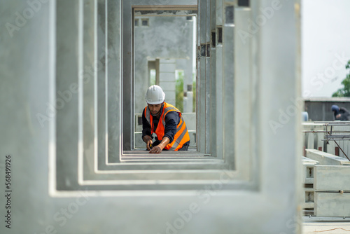 Male engineers are inspecting and controlling the work of the employees and the quality of the manufactured products to meet the standards In industrial factories producing precast prefabricated walls photo