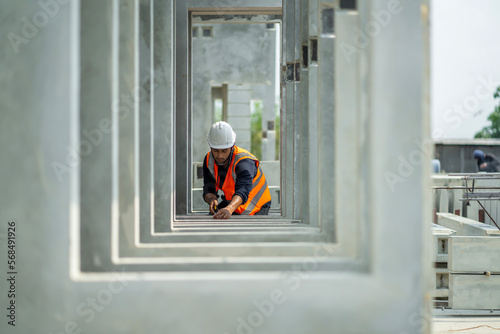 Male engineers are inspecting and controlling the work of the employees and the quality of the manufactured products to meet the standards In industrial factories producing precast prefabricated walls